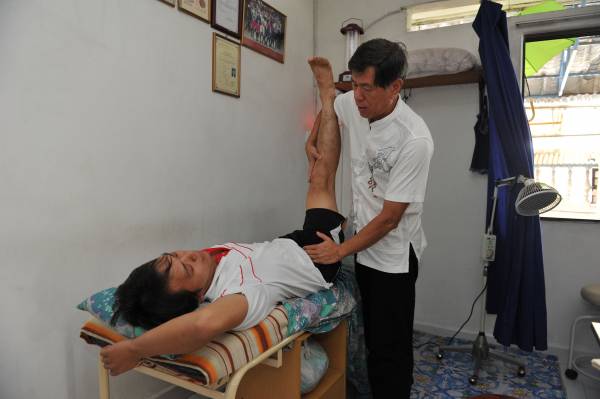 郭医师把病患的脚抬至30度,就可以检验出脊椎移位的问题。