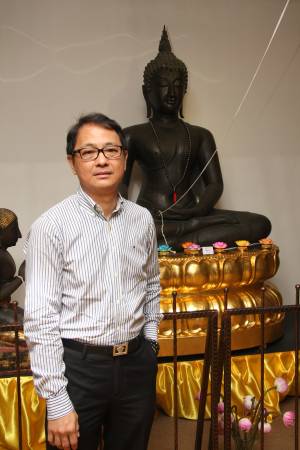 洪镇鹏是“新加坡古佛佛行”的创办人 ,其身后的古佛便有八百年历史,据说市值两百万美元。