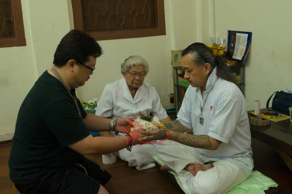 Master Kenny在Mae Ood陪同下给善信施法。