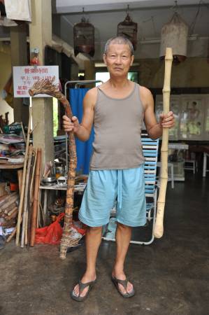 詹达明拿出其“珍藏”让笔者欣赏,右边即是长得很像龙头拐杖的倒生藤和实心竹(左边)。