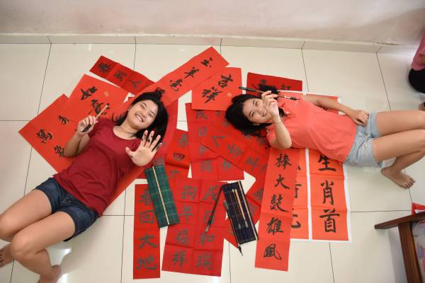 双胞姐妹雯倪(左)及雯迪自幼学书法,每逢新年更是亲自挥毫春联送给亲友,如同把双倍的祝福赠送给亲友。