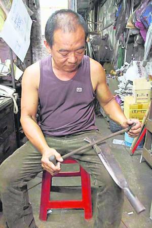 游陆辉展示及讲解操作古老手工磨铁工具。