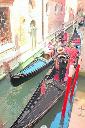 古典梦幻浪漫船只贡多拉(Gondola),以及穿着条纹T恤,撑着船杆的帅气船夫。