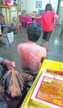“老佛爷”在善信背后画符,有补运去厄之功效。