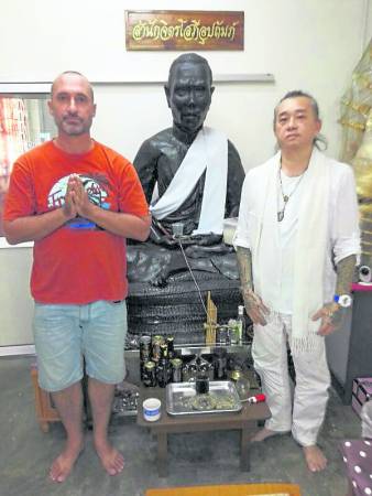 Jo在接受阿赞K大师施法后,在阿赞丰像前虔诚留影。