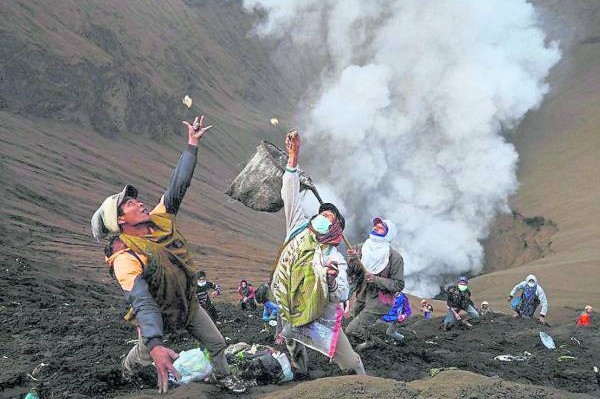 数百名印尼人,拿着网兜来到火山口边,准备接住当地腾格尔部族为祭祀山神而扔进火山口的供品,以期求得好运。