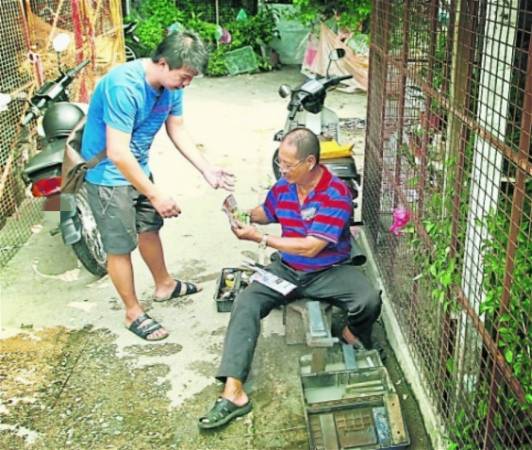 陈治材就地在小巷内为熟客磨刀。