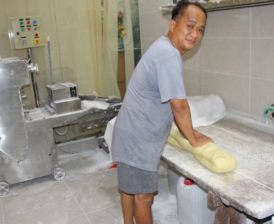 在搓云吞面的面团时,仍保留采用人工。
