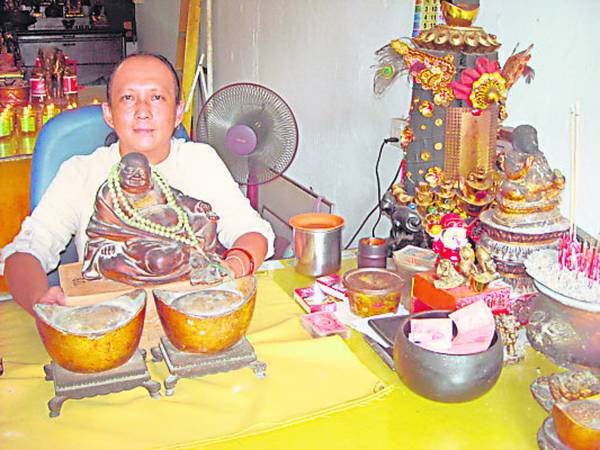 四面神坛主持人林明融师父与弥勒笑佛,有缘的善男信女摸一摸,财源滚滚来。