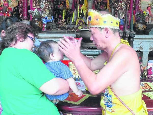 木吒公画好灵符，摸头、摸心，再喝下符水，孩子就不再哭闹了。
