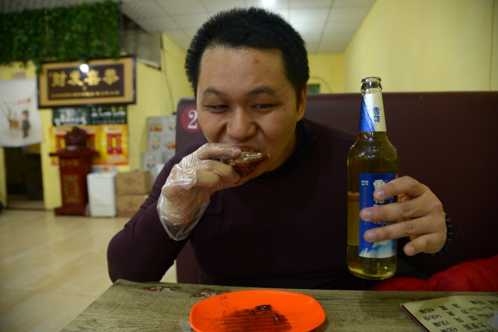 记者入乡随俗,也来一个兔头,一支啤酒暖胃!