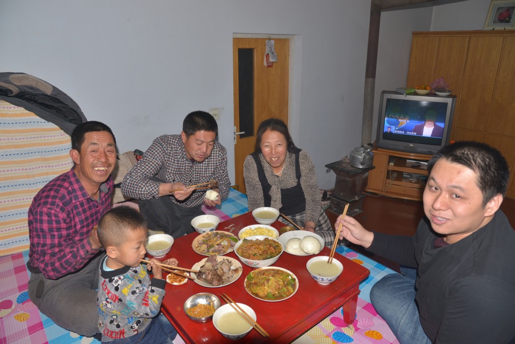 霍彪举(左二)与妻子曾凤英(右二)以丰盛的菜肴,热情招待远方来的记者。