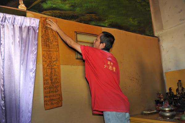 郭师父办事的“密室”，平时会用布盖着，门口贴着有泰国灵符。