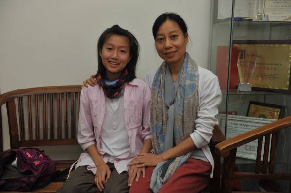 张娟（左）特地从广州飞来新加坡找毛医师为女儿治疗骨头歪曲的问题。