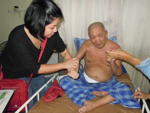 父亲替病人治疗时，符瑜玲从旁协助处理。 