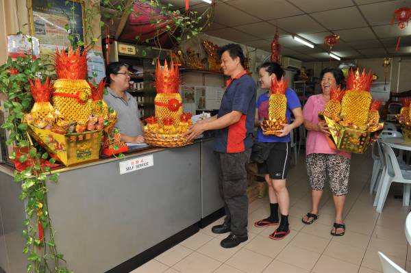 有许多慕名而来的顾客到高燕萍店里购买旺气十足的金凤梨。