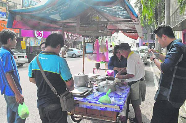 老街坊喜欢围在三轮车旁，一边享用美味麦粥，一边话家常。