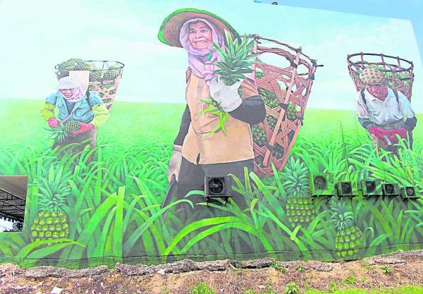 十二月初宣告“完笔”的30尺高大壁画“骄阳下的黄梨海”,出自当地名画家蔡文涛手笔。
