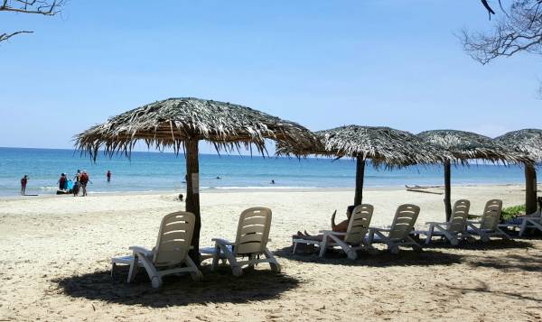 白皙的沙滩上设有一个个的小凉亭，旅客可以坐在椅子上吹吹海风。