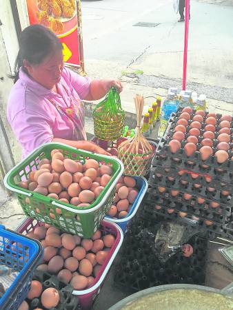佛寺外除了有许多摆卖熟鸡蛋的小档口外，还有许多卖大彩的小摊子！