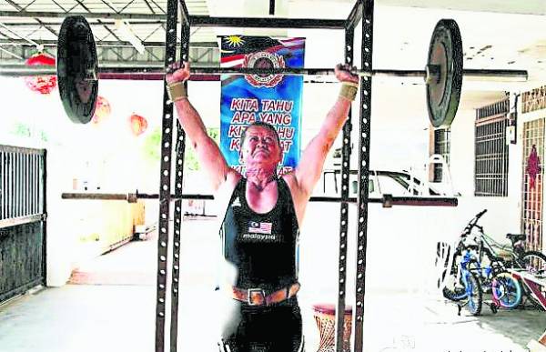 伍潮胜每周6天都会定时训练举重,60多年如一日。
