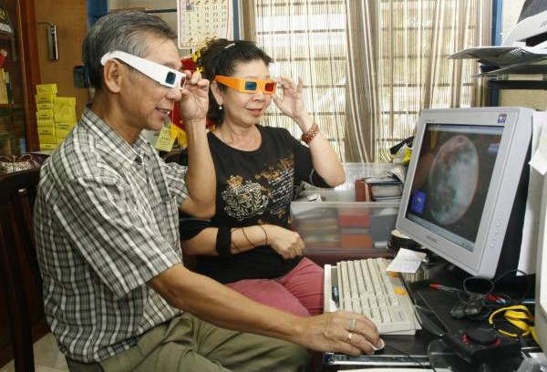 张升荣和何桂花尝兴趣相投,试以3D眼镜观看月球表面。