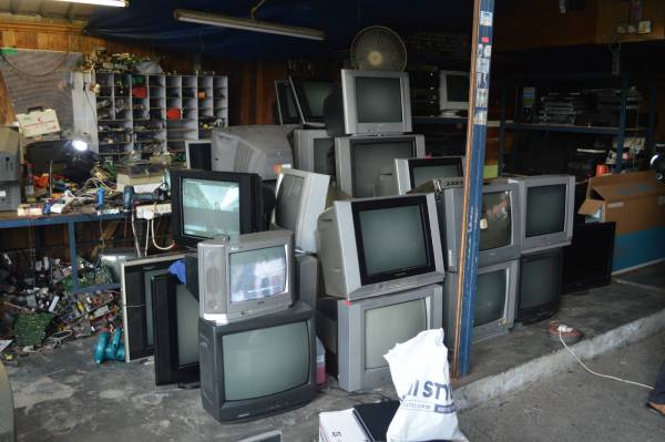 店内各角落都堆满大大小小等待修理的旧式电视机。