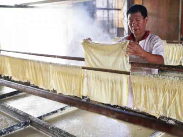 经验老道的吴浚杰制作腐竹技巧熟练，制作的腐竹皮细薄又大小适中。
