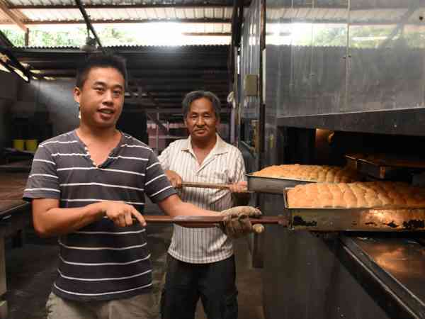 第三代潘家民（后者）与第四代潘在辉（前者）一起打理，每天都会烘烤新鲜的Roti Kok。