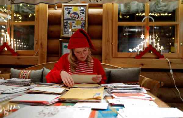 圣诞老人邮局会收到来自世界各地的信，戴上圣诞帽的圣诞老人小精灵伊莲娜正在帮忙分类信件。