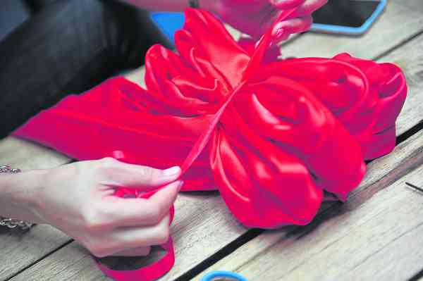 对折好后，用红色缎带在中间把它绑好（*一定要绑紧。）
