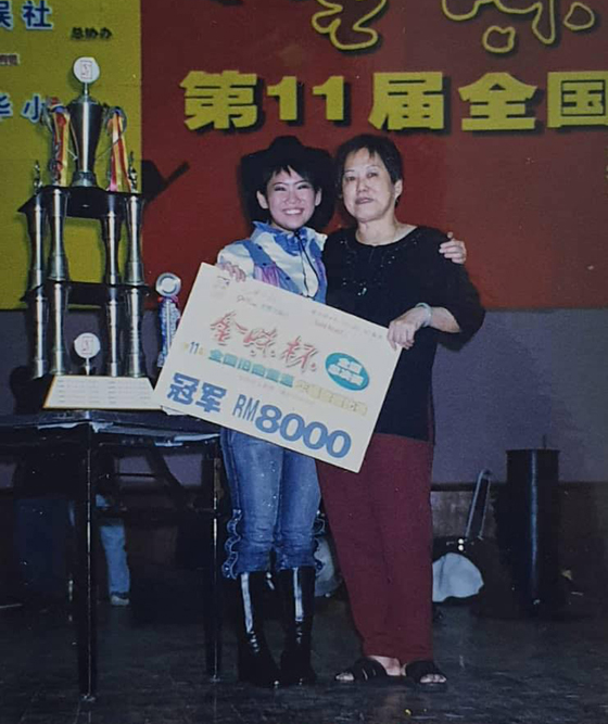 16岁,获得最高奖金的一次歌唱比赛(第一届全国旧曲重温歌唱比赛)夺得冠军,右边是Selina的外婆。