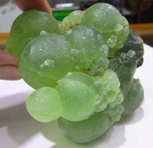葡萄状球形晶体原矿的颜色仿佛刚刚剥去果皮的青葡萄,晶莹的绿色中泛着鲜嫩欲滴的光泽,悦目,让人想咬一口。