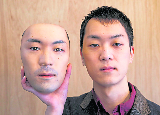 拿着 3D人脸面具的大川原脩平，这顶面具以他的脸制成，上架后很快就销售一空。