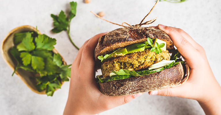 Vegan sandwich with chickpea patty, avocado, cucumber and greens