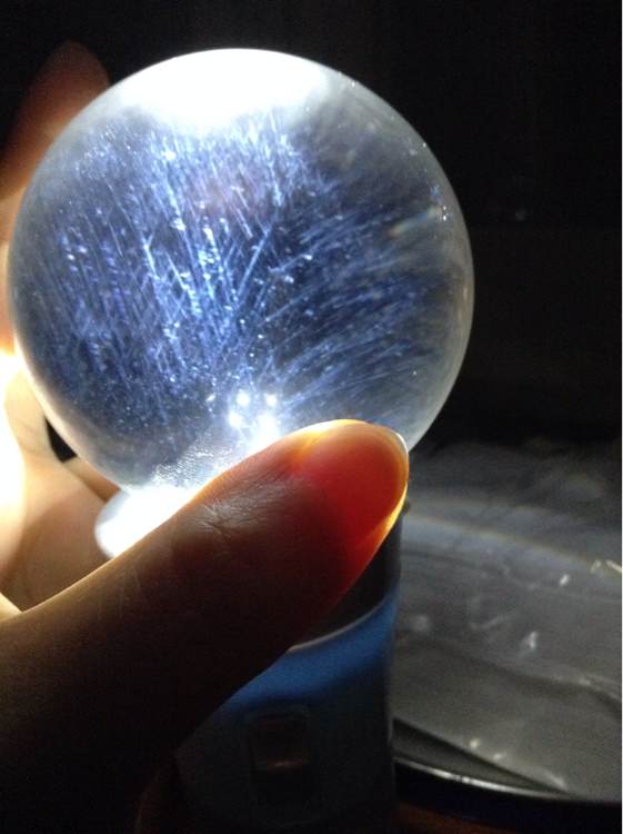 在强光灯下看晶体内部有蓝色的“针状”的包体一层层像羽毛一样。