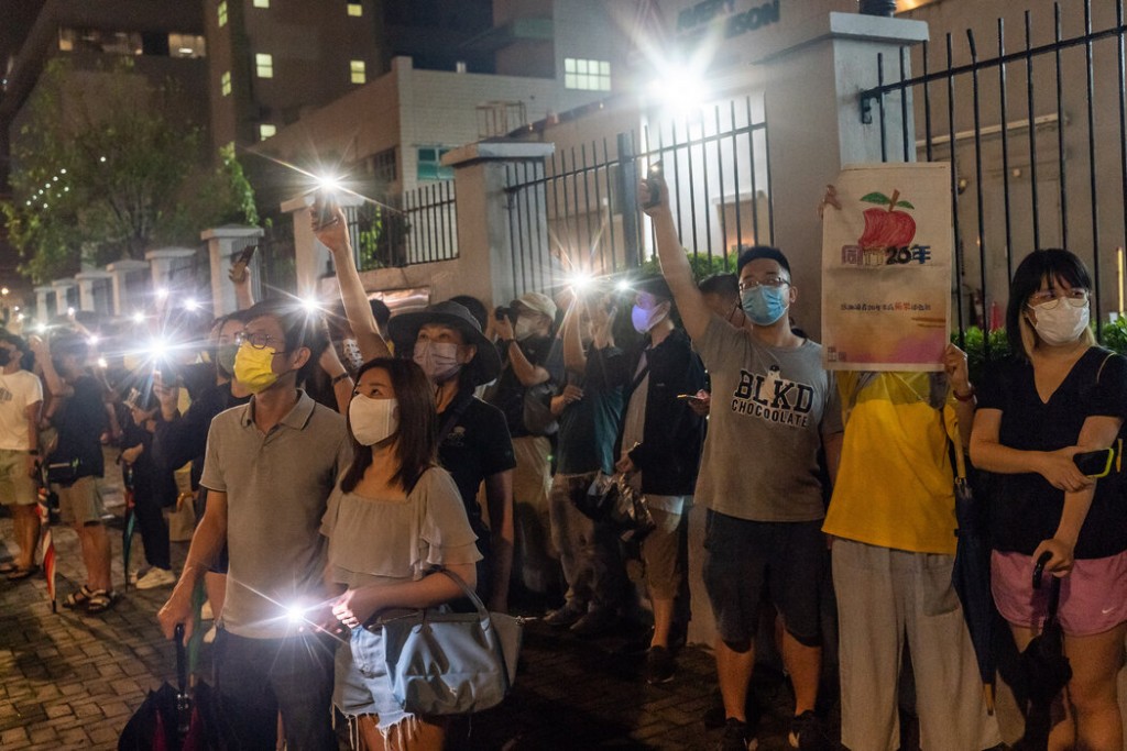6月23日,支持者们打开手机闪光灯,照向《苹果日报》办公室。