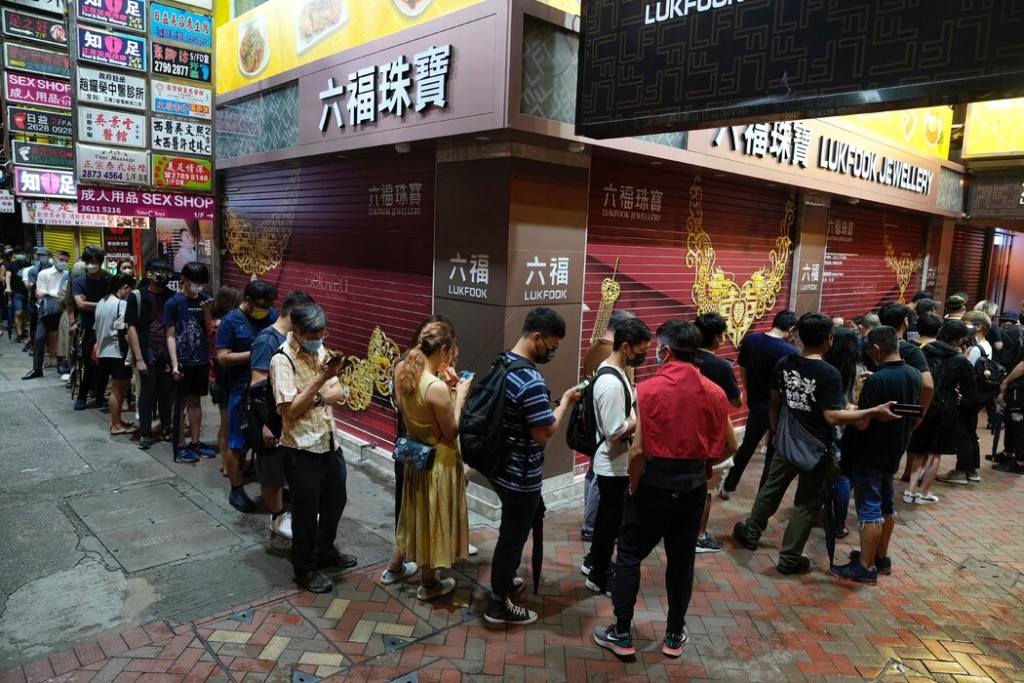 香港民众在一个报刊亭附近排队购买最后一期《苹果日报》。