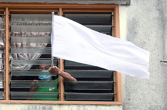 A man waving a white flag at his flat in Puchong. The white flag waving campaign is hoped the help people who need help during the MC0.3.0 (June 29, 2021) — AZHAR MAHFOF Photo : THE STAR / ASIA NEWS NETWORK##########x##########THE STAR / ASIA NEWS NETWORK