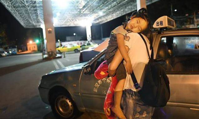 李少云抱着熟睡的女儿,行走在夜色中。