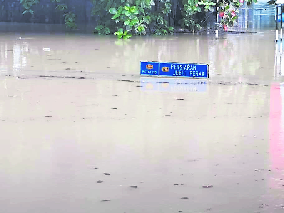 洪水水位高到遮挡了路牌。