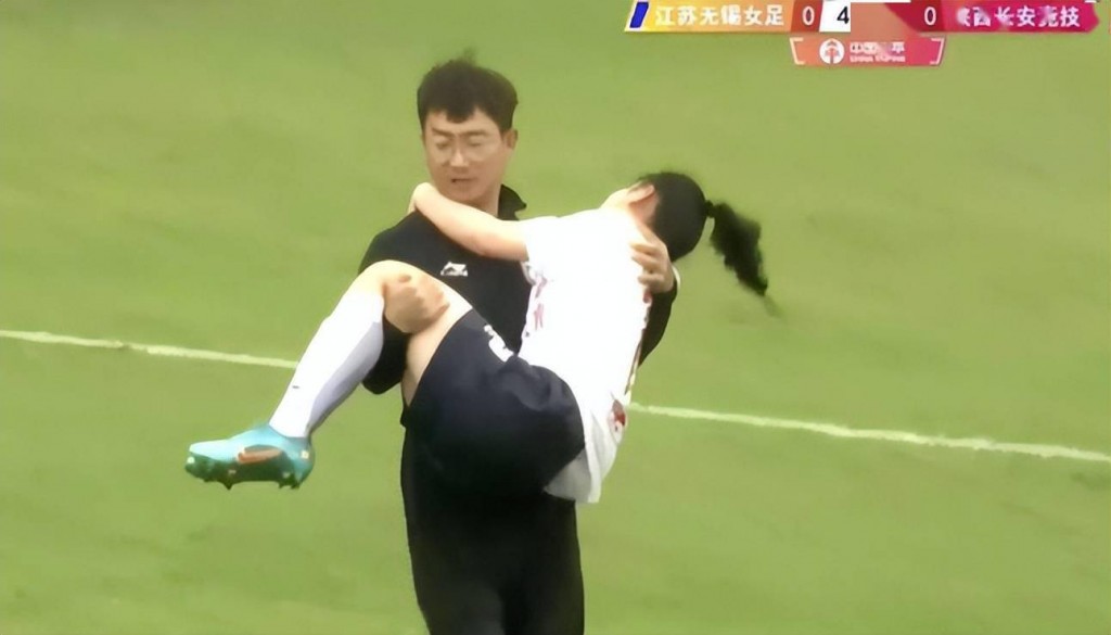 陕西长安竞技球员王芦荟倒地受伤，由队医抱离场。