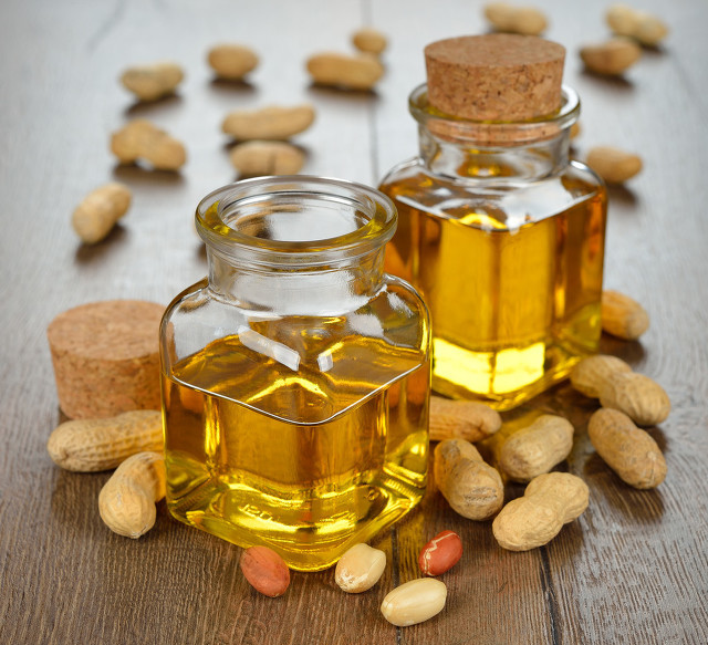 Peanut oil in a glass bottle on a brown background