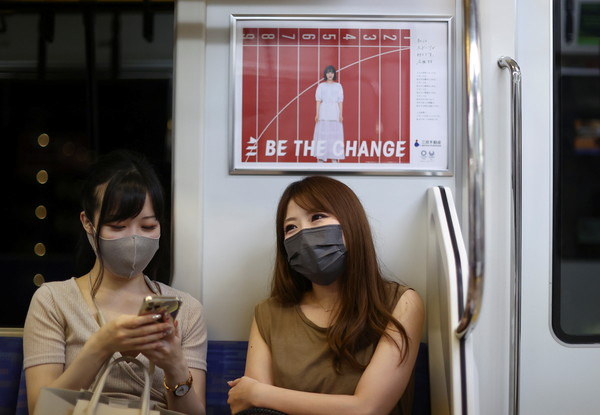 Women sit in a train during Tokyo 2020 Olympic Games, amid the coronavirus disease (COVID-19) pandemic, in the Chinatown of Yokohama, Japan  August 3, 2021. Picture taken August 3, 2021. REUTERS/Jorge Silva