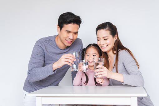 Happy Asian family drinking fresh water for healthy concept
