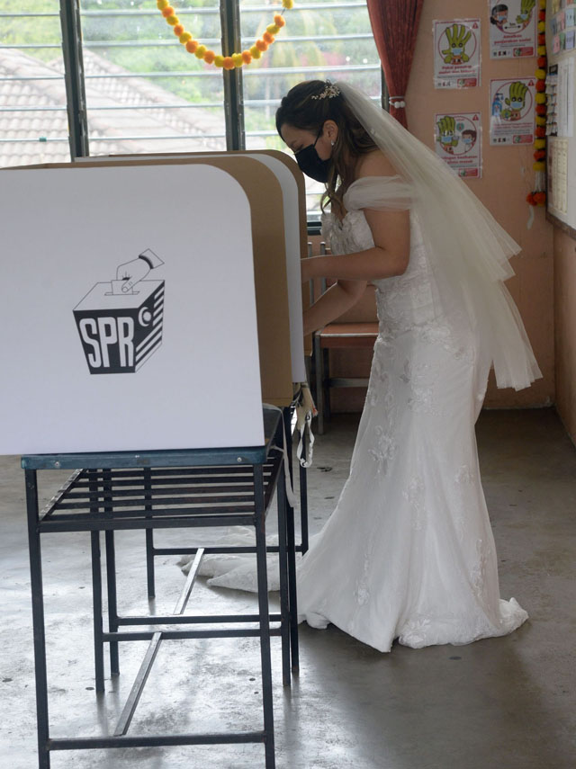 穿上雪白婚纱的新娘子一天内要完成结婚与投票这两件人生大事。