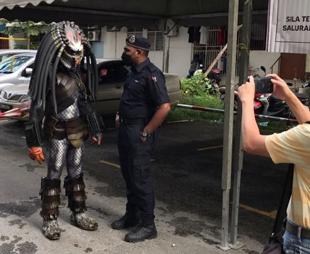 “终极战士”( Predator)被警员拦下,引起公众好奇围观,举手机拍摄。