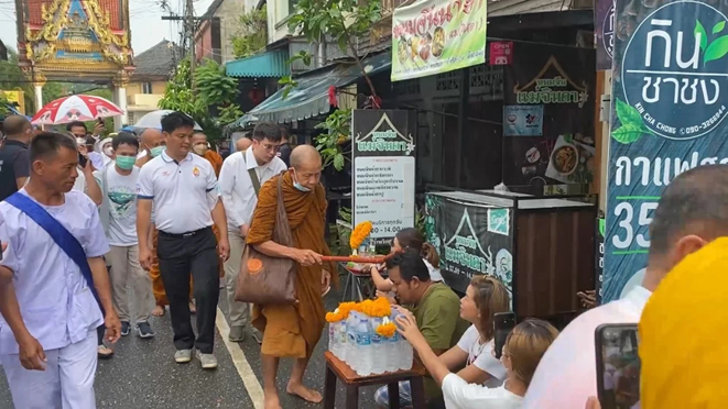 信徒们冒着大雨恭候Luang Ta Bun Chen,而他也为信徒敲头祈福。