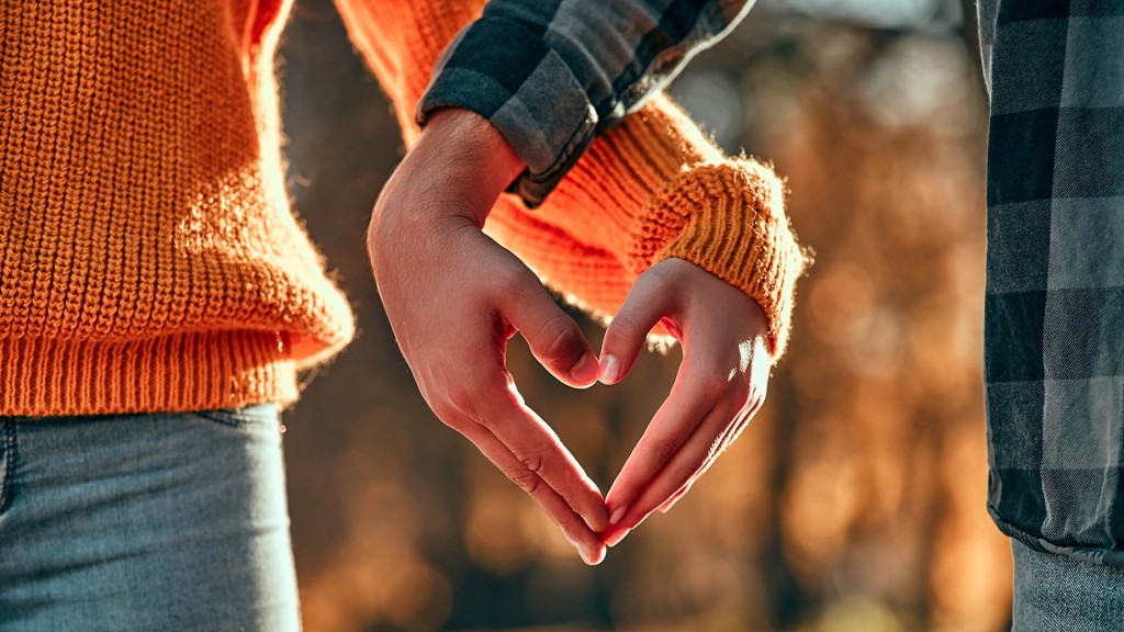 Cropped image of young couple walking in park in autumn time.