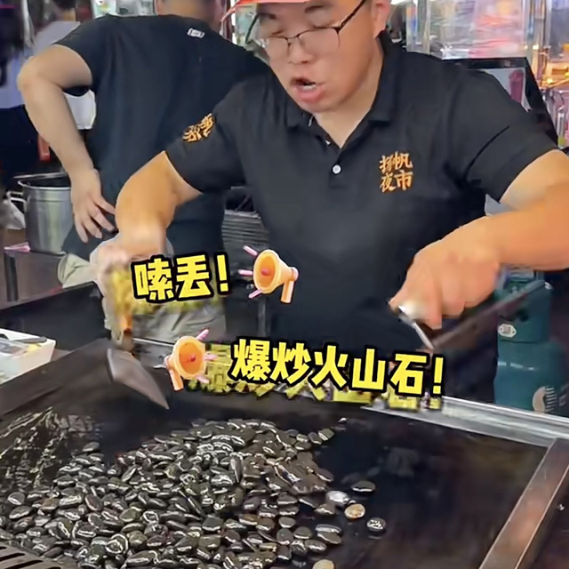 摊贩档主正在爆炒鹅卵石时,念念有词唱起顺口流。